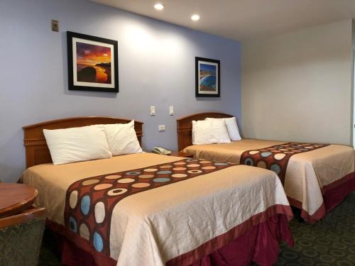奥兰治奥兰治橙色塔斯廷酒店的一间酒店客房内设有两张床的房间