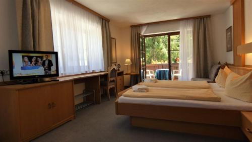 柯尼希斯湖畔舍瑙库尼格斯酒店的酒店客房设有床、电视和窗户。