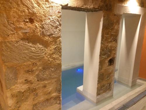 干尼亚Antica Canea Luxury Rooms的一间设有石墙和游泳池的房间
