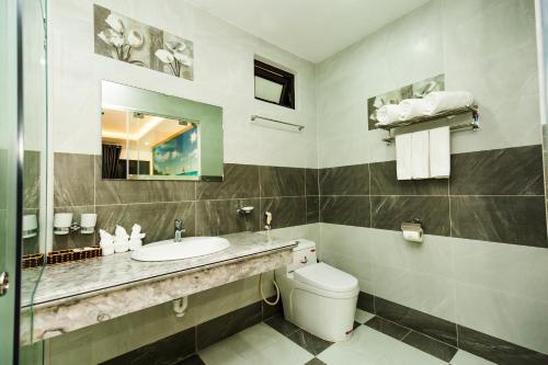 海防TRUNG KIÊN HOTEL的一间带水槽、卫生间和镜子的浴室