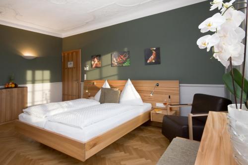 哈格瑙德尔明镜罗温酒店的卧室配有一张白色大床和一把椅子