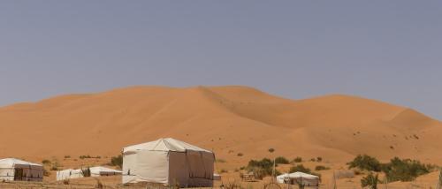 Lac YasminsMorocco Deluxe Camp - Assif n'Itrane的一片沙漠,有帐篷和一大堆沙