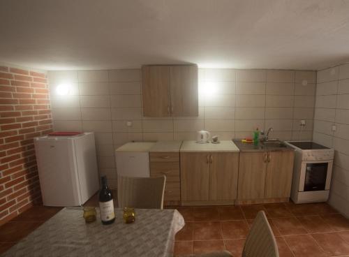 威尔帕扎Cicvaric rooms的厨房配有冰箱和带一瓶葡萄酒的桌子。