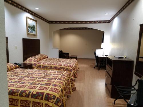 休斯顿Scott Inn & Suites - Downtown Houston的酒店客房配有两张床和一张书桌