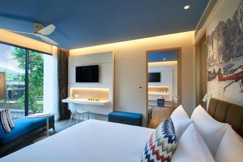 卡塔海滩普吉岛遨舍度假酒店的一间卧室配有一张床、一张桌子和一个水槽