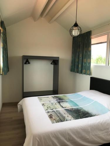 米德尔克尔克Vakantiewoning De Zandkorrel的卧室配有白色的床和窗户。