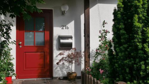 纽伦堡Ruhiges Zimmer Nähe Nürnberg Messe mit Wallbox的红色的大门,房子上装有邮箱