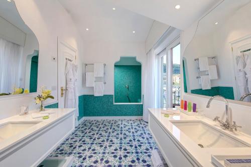 索伦托安巴夏托理大酒店的浴室配有2个盥洗盆和1个浴缸。
