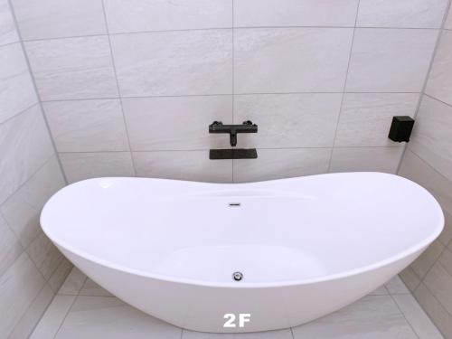 东京HAKU HOTEL的浴室配有白色浴缸及水龙头