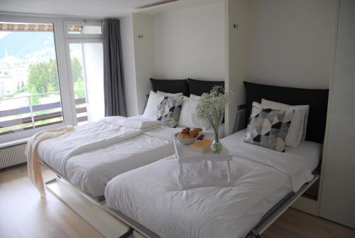 达沃斯Davos Holiday Apartment的带窗户的客房内设有两张单人床。