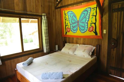 卡维塔Hotel & Cabinas Nadine的一间卧室配有一张床上,墙上挂着蝴蝶画