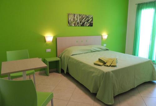 维拉西米乌斯阿尔丘平淘酒店的绿色卧室配有床和桌子