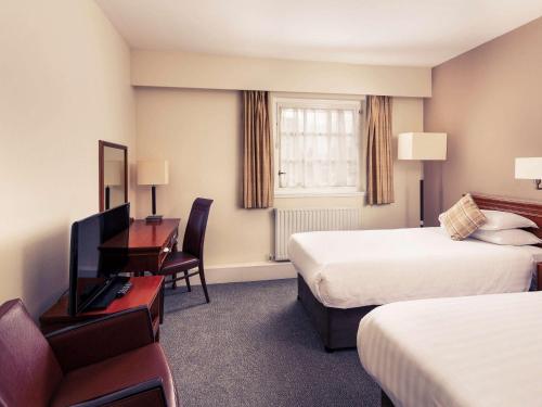 珀斯珀斯美居酒店的酒店客房配有两张床和一张书桌