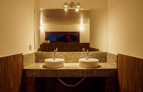 加利纽斯Pousada Brésil Aventure的带大镜子的浴室内的2个盥洗盆