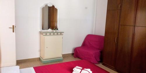 HermadaCasa Vacanze Terracina的一间设有红色床和椅子的房间