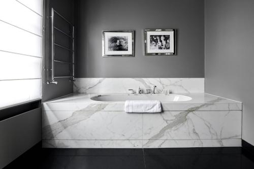 布鲁塞尔奥德特维尔酒店的白色的浴室设有浴缸和水槽。