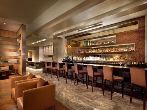 迈阿密迈阿密机场EB酒店的餐厅内的酒吧,带棕色椅子