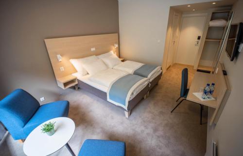 莱达尔绥里莱德尔酒店的一间卧室配有一张大床和蓝色的椅子