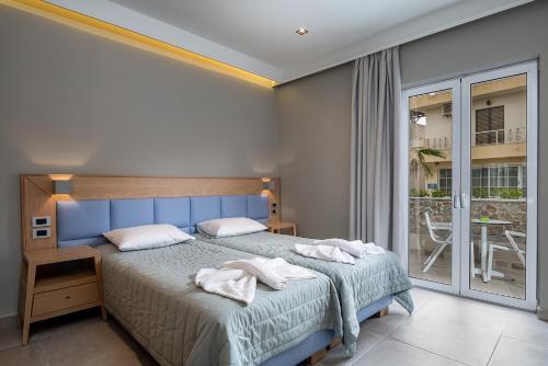 卡尔扎迈纳Argiri Resort Hotel & Apartments的一间卧室配有一张床,上面有两条毛巾