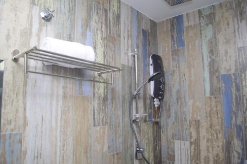 瓜拉丁加奴Rest And Comfort Boutique Hotel的带淋浴的浴室,墙上配有电话