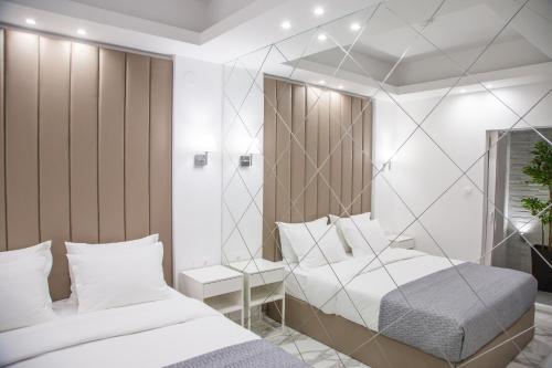韦里亚Veria Luxury Suite的一间卧室配有两张床和镜子