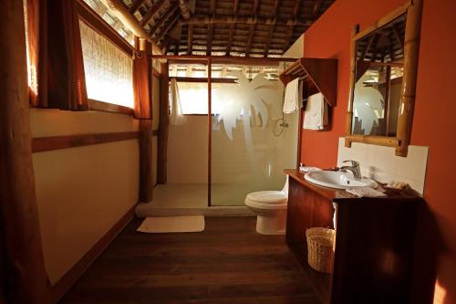 MkwajaBarry's Beach Resort的一间带卫生间、水槽和镜子的浴室