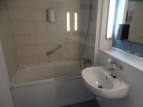 布鲁日布鲁日超值住宿宾馆的浴室配有水槽、淋浴和浴缸。