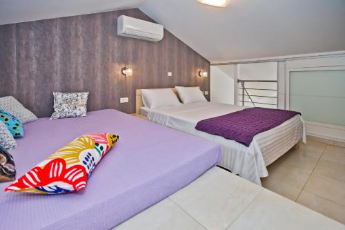 赫瓦尔Island Hvar Seaside Villa Levanda with Beach, Pool & Seaview的紫白色客房的两张床