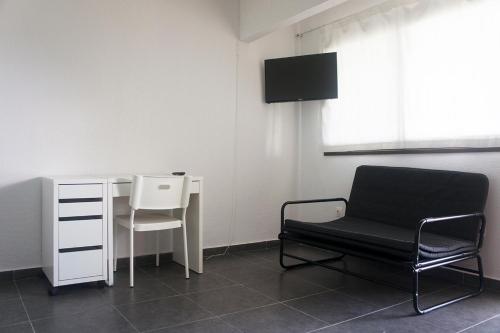 卡兰兹拉Possidi Aigaiopelagitika ground floor beachside studio的一间带椅子、一张桌子和一把椅子的房间