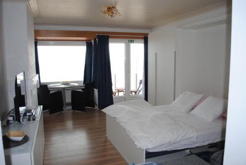 奥斯坦德De Zee的一间卧室配有一张床、一张书桌和一个窗户。