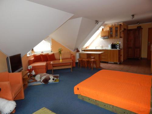 特尔乔夫Apartmány v Terchovej的客厅配有橙色家具,地板上放着一只狗