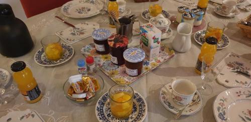 沙勒维尔-梅济耶尔La Ferme De Saint Julien的桌子上放有盘子和橙汁杯
