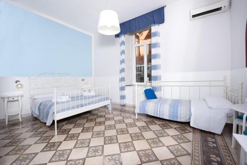 那不勒斯Napoli Experience的一间卧室设有两张床、一张桌子和一个窗口