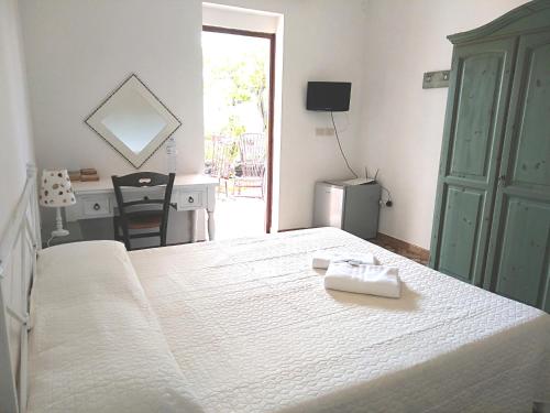 阿雷内拉拉维德尔玛雷住宿加早餐旅馆的卧室配有一张白色的床、一张桌子和一张书桌。