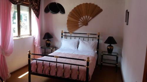 FajãCasa do Costa的卧室配有一张床铺,墙上装有风扇