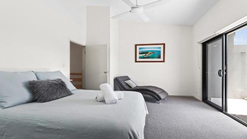 拜伦湾Aqua on Fletcher Street的白色卧室配有床和椅子
