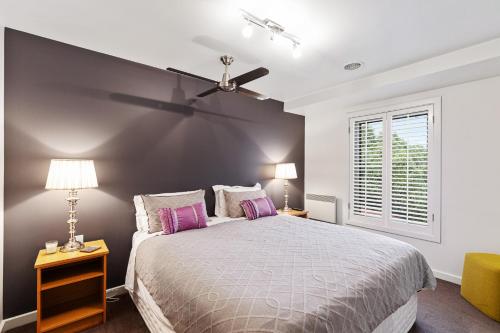 芒特甘比尔Frewville 7A Apartment的一间卧室配有一张床和吊扇