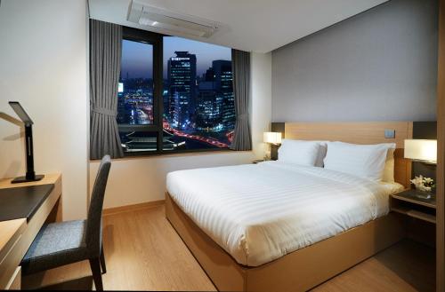 首尔Fraser Place Namdaemun Seoul的一间卧室配有一张床、一张书桌和一个窗户。