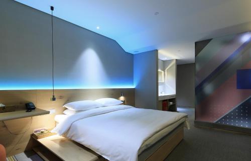 杭州忆泊酒店（杭州西湖店）的一间卧室设有一张蓝色天花板的大床