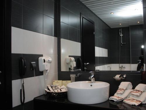 鲁塞丽都疗养酒店 的一间带白色水槽和电话的浴室