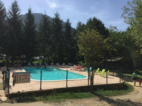 Ispagnac勒瓦隆酒店的公园内的游泳池,有椅子和树木