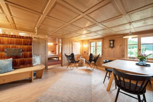施瓦岑贝格WÄLDERHAUS Apartments的客厅设有木制天花板和桌椅
