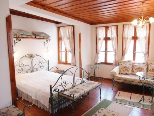 梅尔尼克德斯博斯拉夫餐厅酒店的一间卧室配有一张床、一张沙发和窗户。