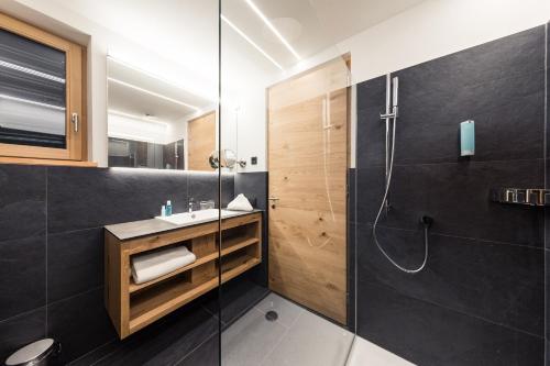 卡尔达罗Weingut Moser Apartments的带淋浴和盥洗盆的浴室