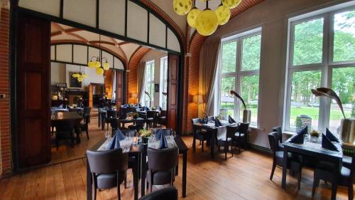 HoevenConferentiecentrum Hotel Bovendonk的用餐室设有桌椅和窗户。