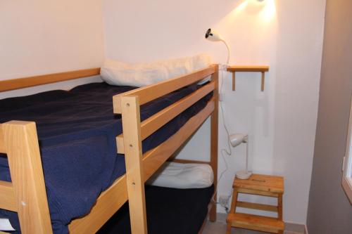瓦劳里埃le petit bois的一间卧室配有两张双层床和一盏灯。