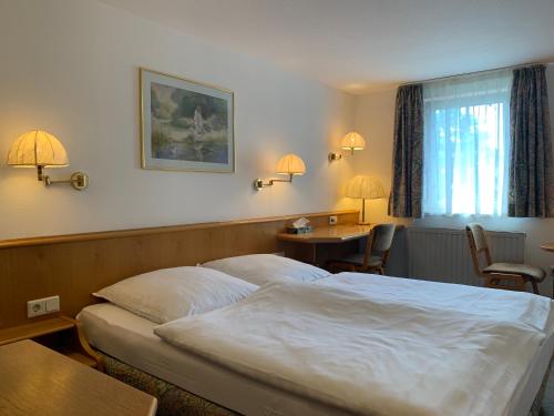阿斯佩格Gasthof zum Bären的酒店客房带一张床、一张桌子和椅子