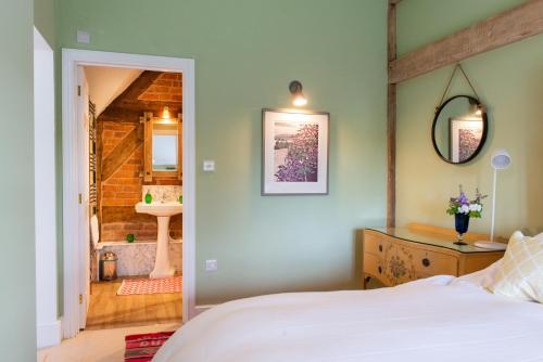 莱明斯特The Hayloft, Wall End Farm的一间卧室设有一张床和一间浴室。