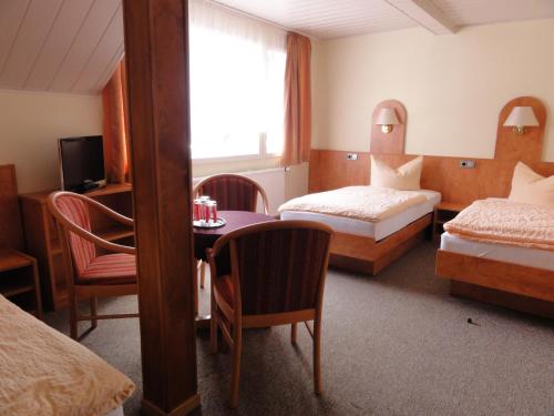 爱尔福特Hotel Garni Melchendorf的酒店客房设有两张床和一张桌子。