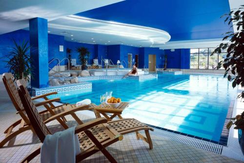 金塞尔Actons Hotel Kinsale的一个带椅子和背景女性的大型游泳池